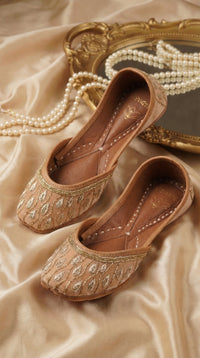 Noor Zardozi Leaf Jutti Pair – Flat Lay with Antique Gold Mirror & Pearl Necklace by Radiarte