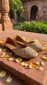 Kanak Champagne Gold Kundan Jutti by Radiarte – Flat Lay on Heritage Stone with Marigolds
