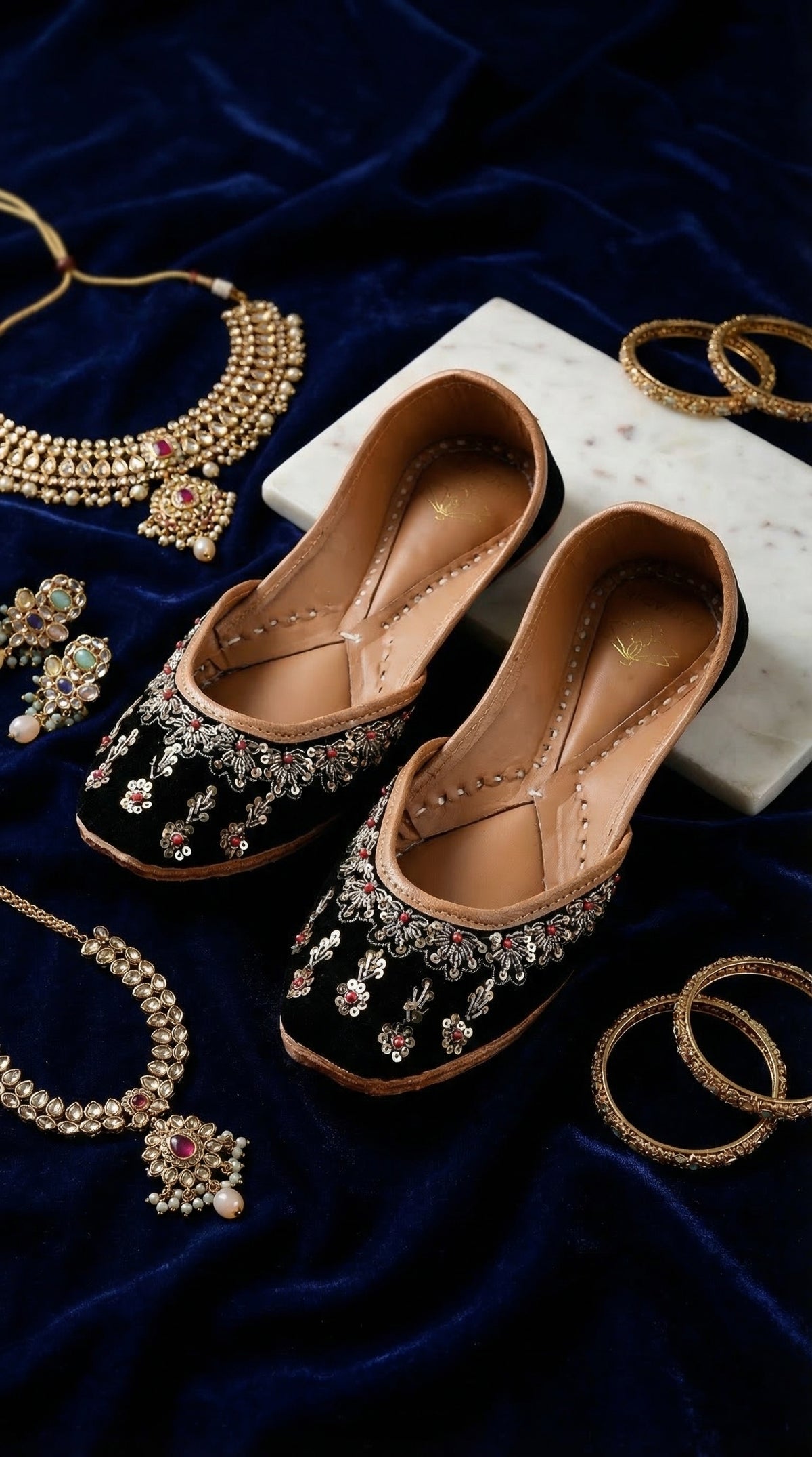 Zehra black velvet embroidered jutti pair – display on navy velvet with kundan necklace and gold bangles Radiarte