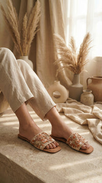 Vriksha boho embroidered slide flat on feet – worn with ivory linen trousers in warm earthy setting Radiarte