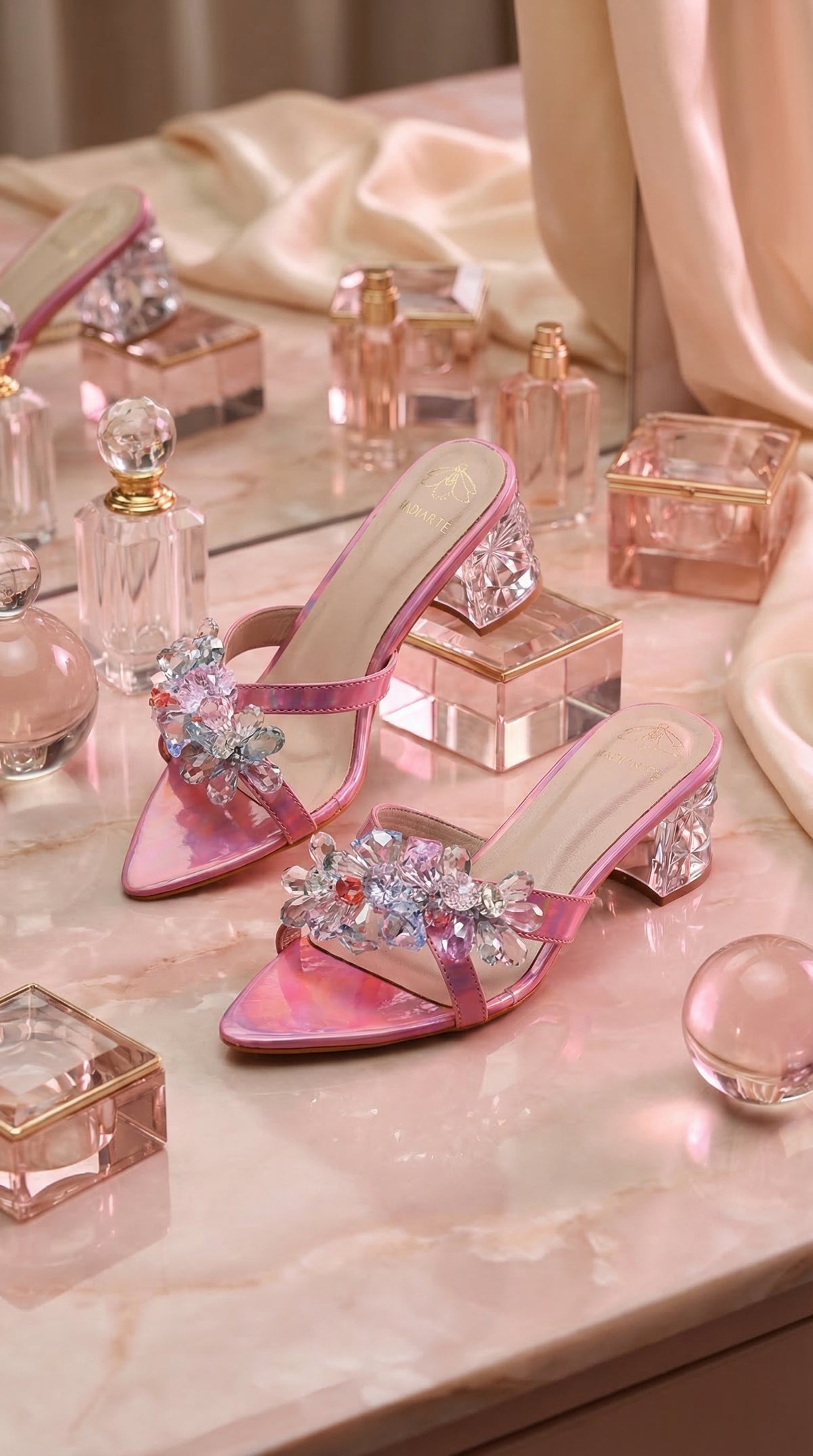 Nova Pink Iridescent Crystal Flower Block Heel Mule by Radiarte – Flat Lay with Perfume Bottles on Pink Marble