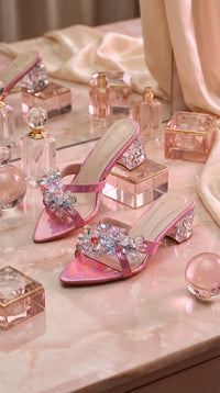 Nova Pink Iridescent Crystal Flower Block Heel Mule by Radiarte – Flat Lay with Perfume Bottles on Pink Marble