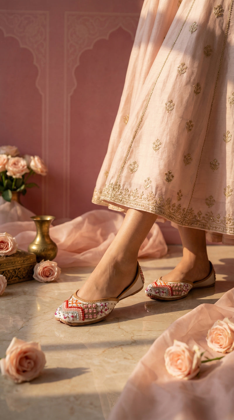 Sitara white embroidered jutti on feet – worn with blush pink anarkali in Mughal courtyard setting Radiarte