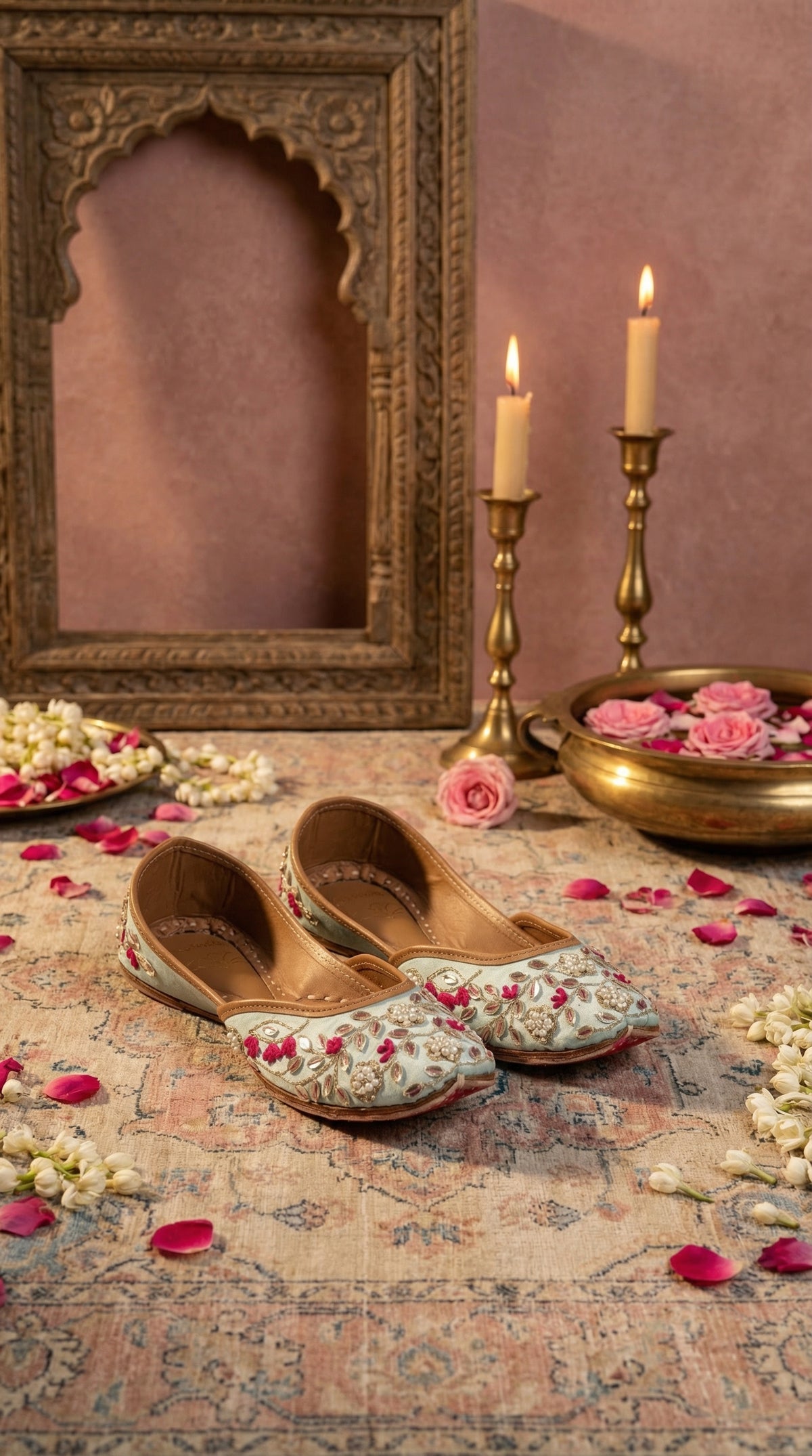 Samundar powder blue floral embroidered jutti by Radiarte – pair on Persian rug with brass candles and roses