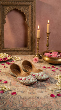 Samundar powder blue floral embroidered jutti by Radiarte – pair on Persian rug with brass candles and roses