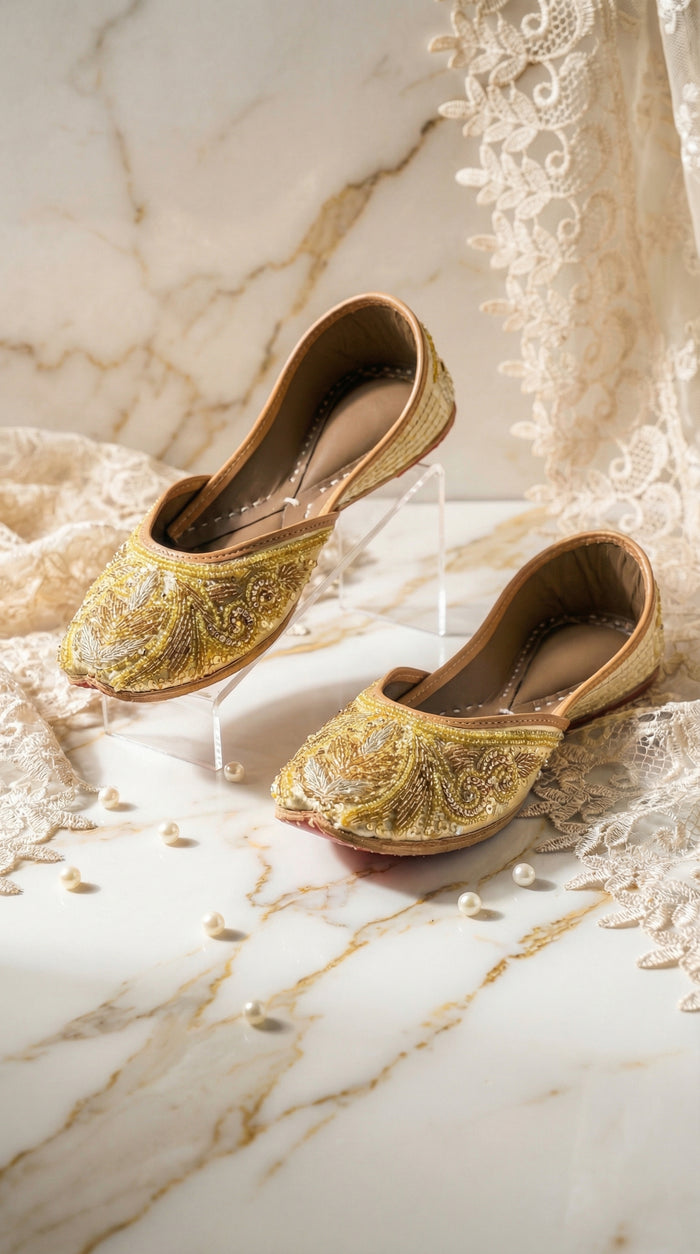 Shararat gold zardozi embroidered jutti by Radiarte – pair on marble with pearls and ivory lace