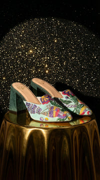 Rio mint green floral embroidered mule heel by Radiarte – pair on gold pedestal against starry background