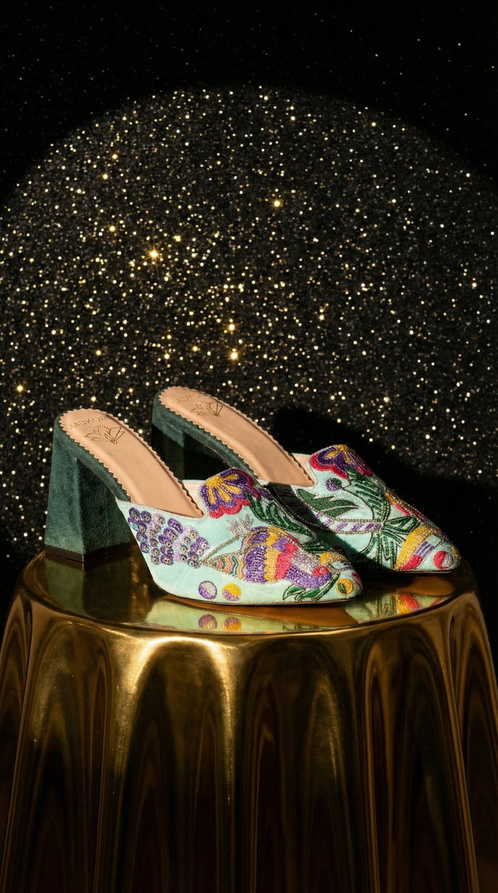 Rio mint green floral embroidered mule heel by Radiarte – pair on gold pedestal against starry background