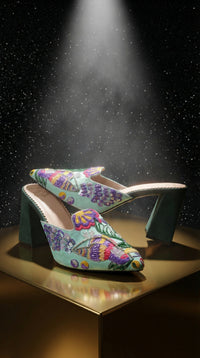 Rio embroidered 3-inch block heel mule – front angle on gold platform with starry backdrop Radiarte