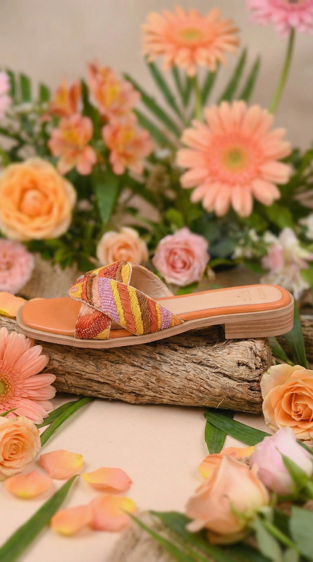 Gulnaar Block Heel Slide with Multicolour Embroidery – Side View on Wood Log