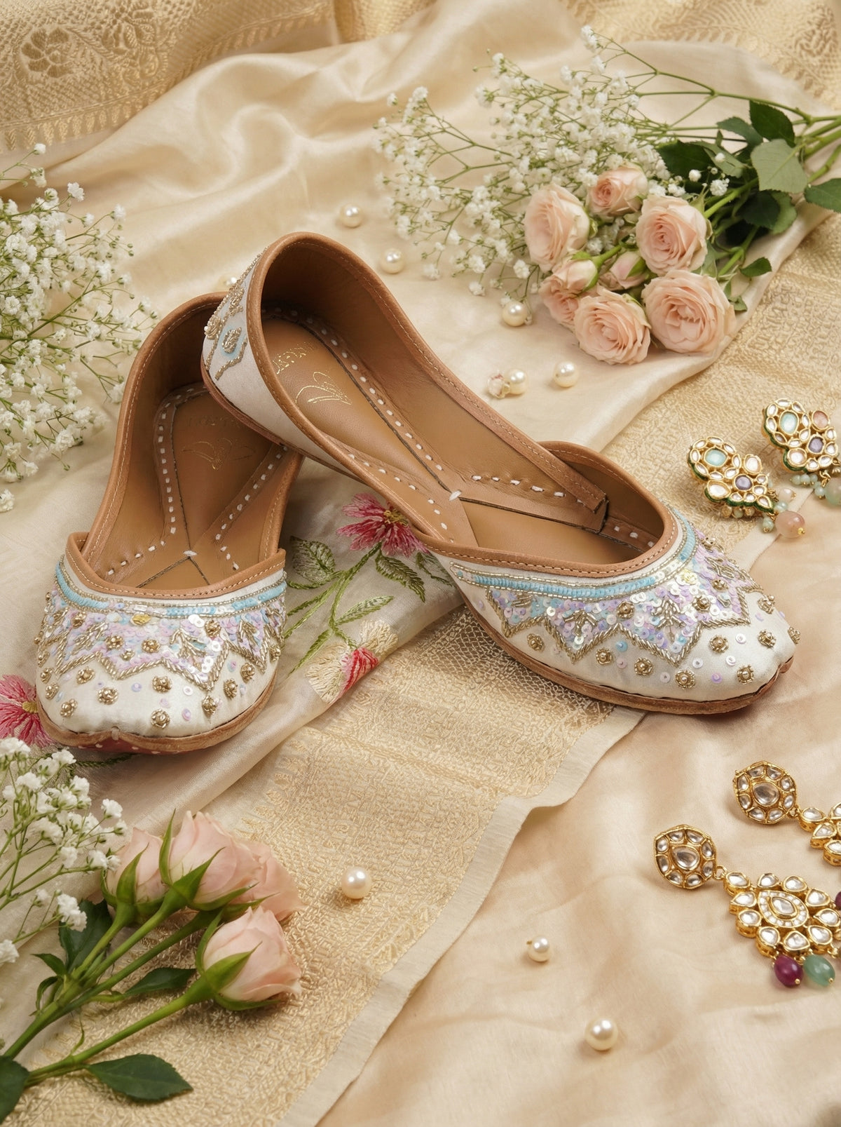 Noorani Ivory Iridescent Jutti Pair – Flat Lay with Pink Roses & Kundan Earrings by Radiarte