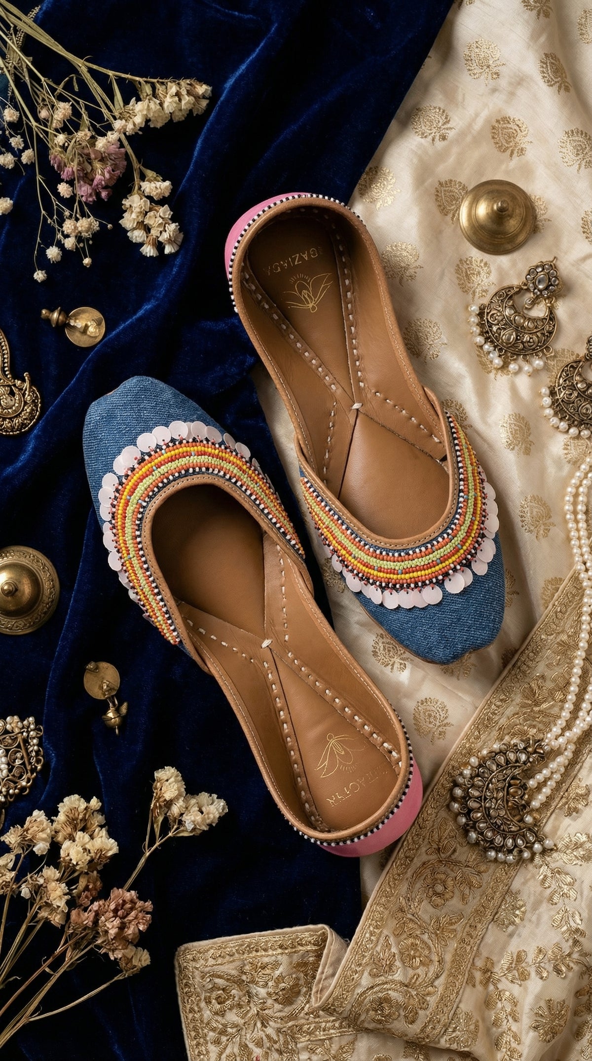 Zyra denim rainbow jutti pair – flat lay on navy velvet and gold brocade with silver jewellery Radiarte