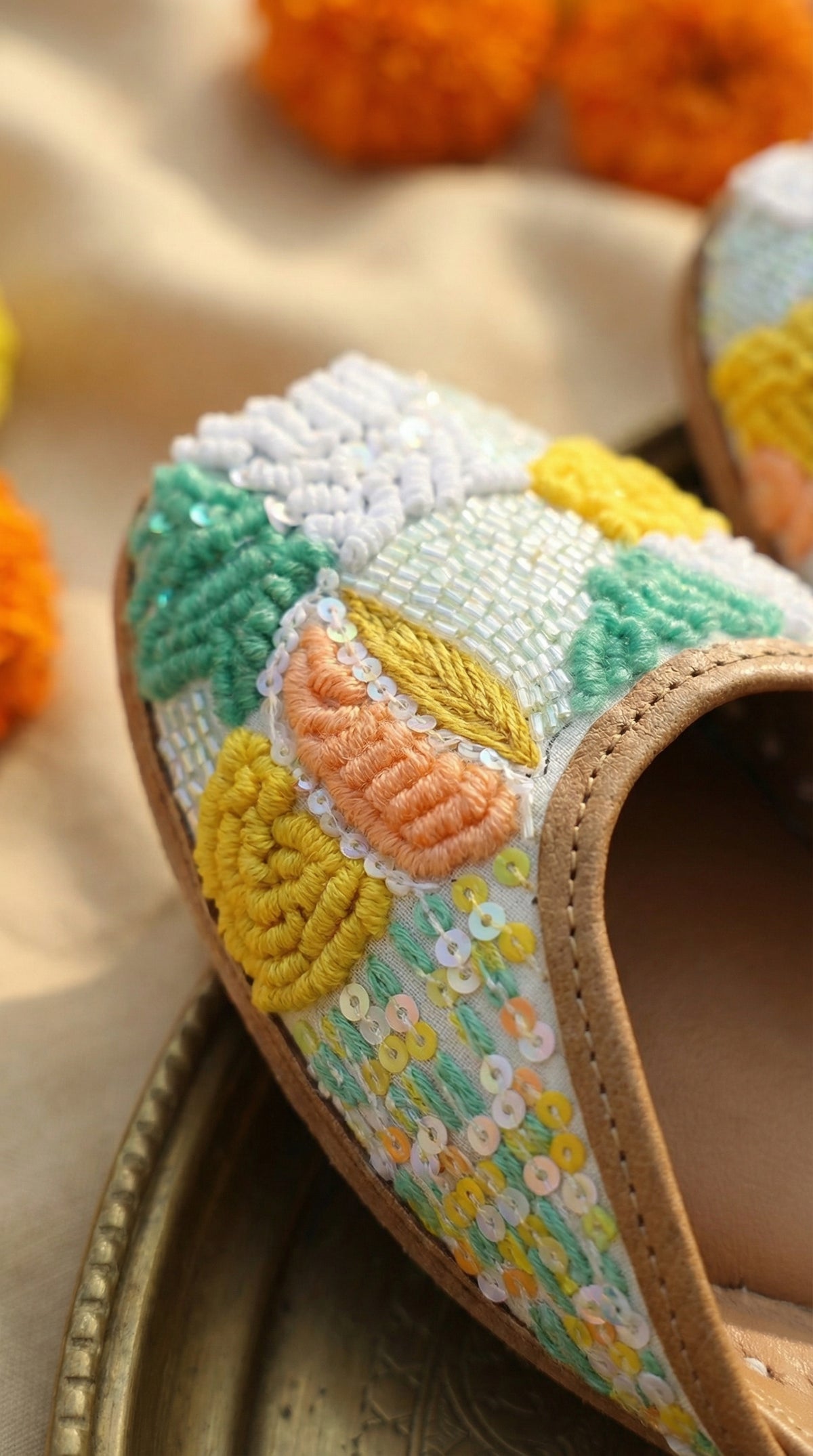 Close-up of Zale iridescent sequin base with raised French knot and satin stitch embroidery – Radiarte jutti