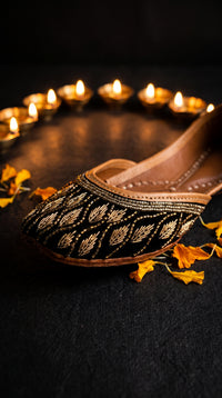 Shabnoor jutti with diya and marigold petals festive flat lay