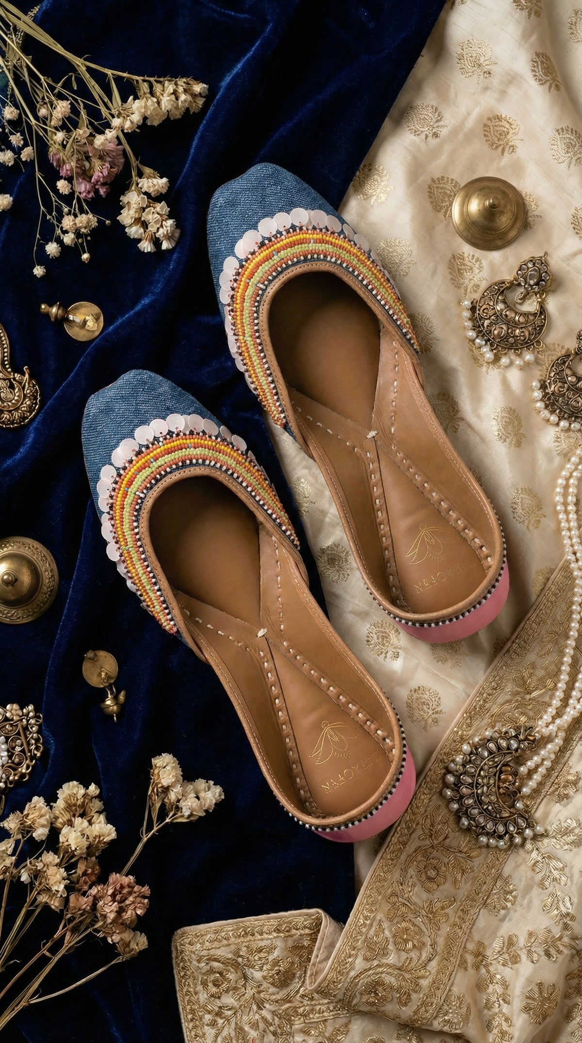 Zyra blue denim bead jutti – top view showing coin sequin border and rainbow stripe arc on navy velvet Radiarte
