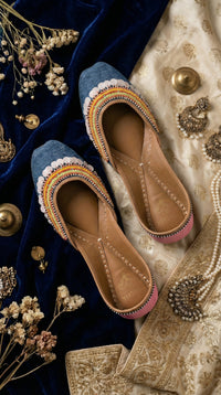 Zyra blue denim bead jutti – top view showing coin sequin border and rainbow stripe arc on navy velvet Radiarte