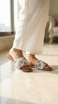 Zaariya white pearl crystal slide flat on feet – worn with white linen wide leg trousers on marble floor Radiarte
