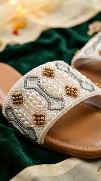 Close-up of Taj white seed pearl shell bead and gold crystal geometric bead work slide flat – Radiarte