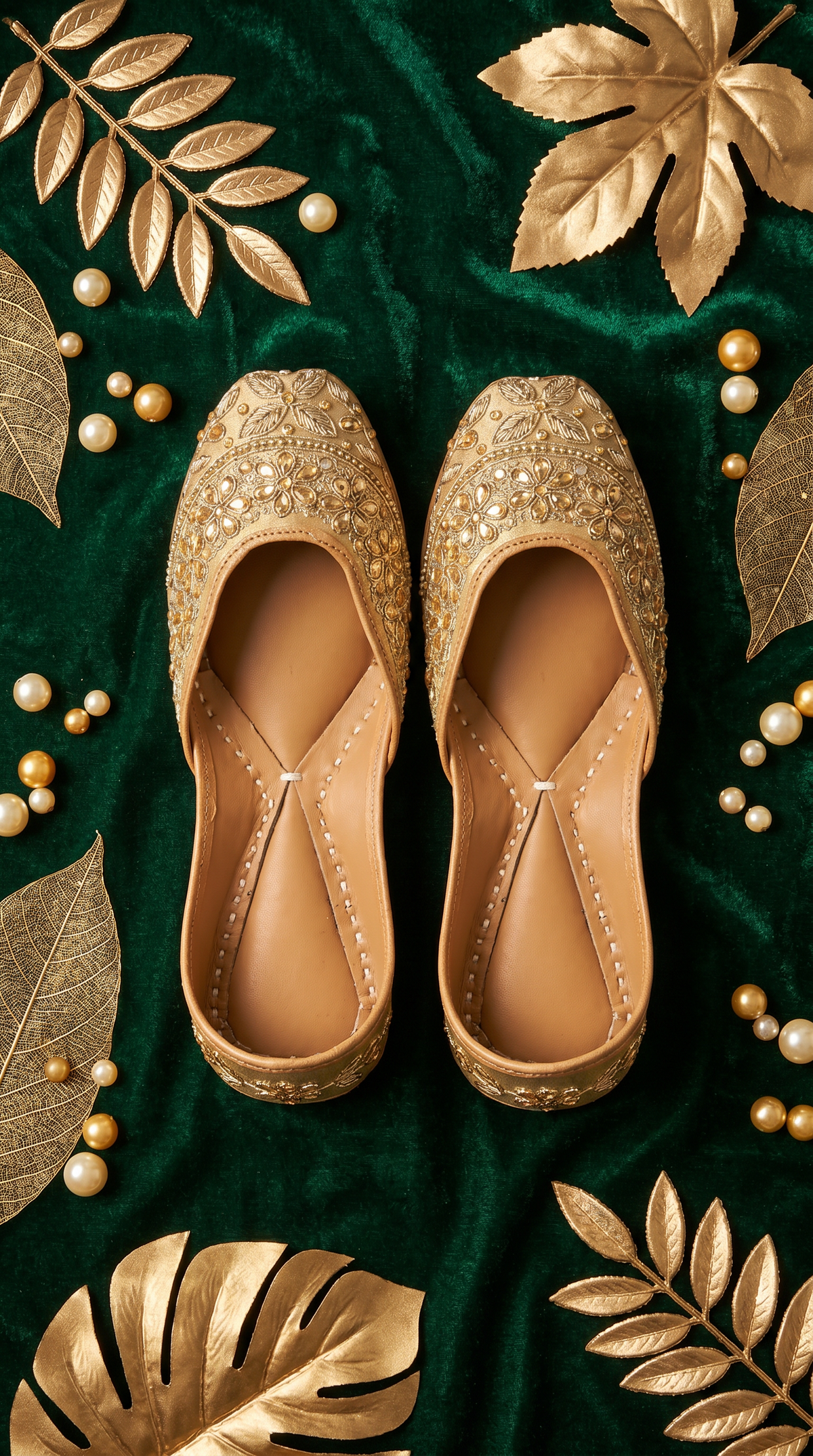 Close-up of Zarrin gold jutti on green velvet with gold leaf décor – handcrafted footwear by Radiarte