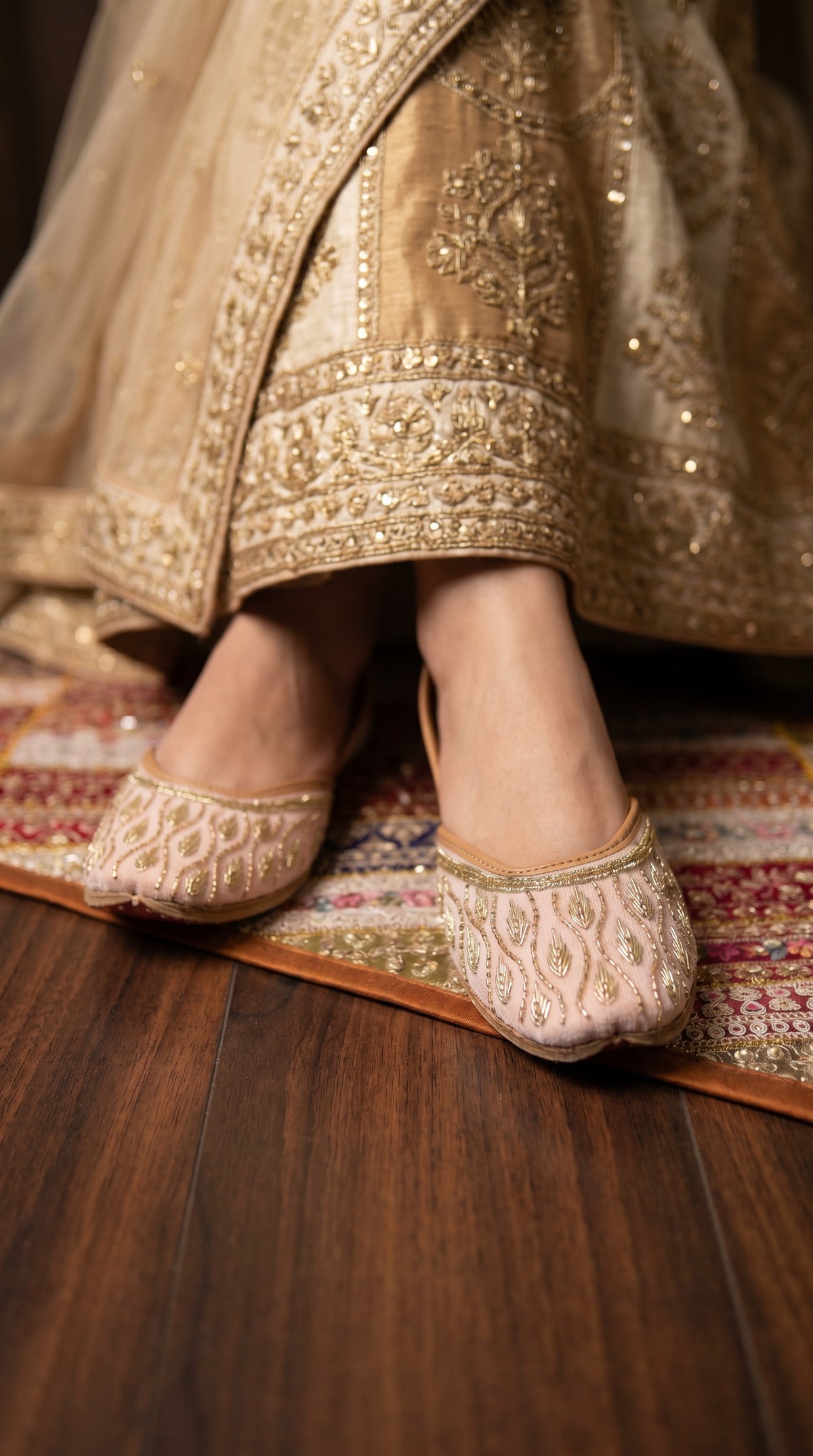 Close-up of Pallavi gold beaded leaf embroidery on blush pink jutti