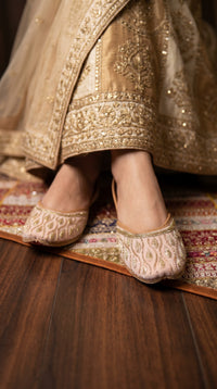 Close-up of Pallavi gold beaded leaf embroidery on blush pink jutti