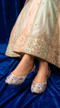 Samundar powder blue jutti worn with pastel green and peach embroidered lehenga – bridal styling by Radiarte