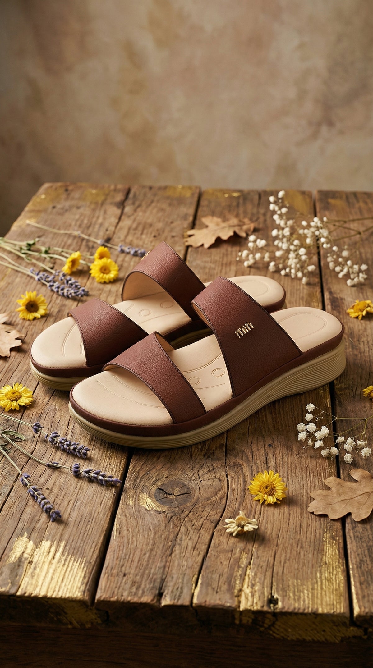 Komal Brown Double Strap Wedge Slide by Radiarte – Flat Lay on Rustic Wood with Wildflowers